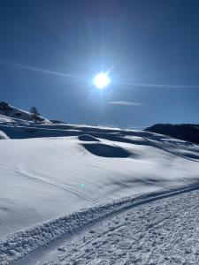 um campo coberto de neve com o sol ao fundo em Appartement Vars Sainte Marie 6 personnes em Vars