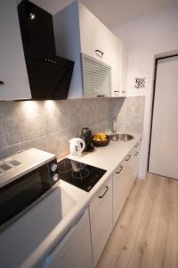 a kitchen with a sink and a stove top oven at theApartments Manufaktura in Łódź