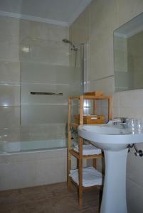 a bathroom with a white sink and a shower at Hostal Monte Rio in Peñamellera Alta
