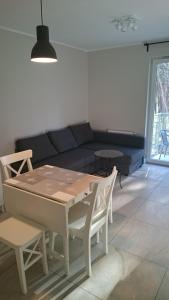 een woonkamer met een bank en een tafel en stoelen bij Apartament 20 in Dziwnówek
