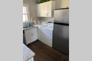 a kitchen with white cabinets and a stainless steel refrigerator at Belmont NC Riverfront 2-Bedroom Garden Suite in Charlotte +30 photos
