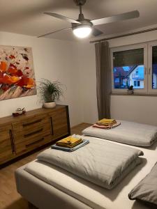 two beds in a room with a ceiling fan at Loft Unterkunft in Hügelsheim in Hügelsheim