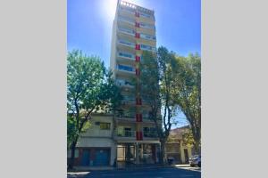 wysoki budynek z czerwonymi oknami obok drzew w obiekcie LUMINOSO Y MODERNO EN CABALLITO w BuenosAires
