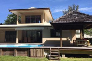 莫雷阿Moorea Temae Villa walking dist beach and golf的一栋前面有游泳池的房子