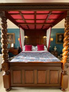 a bedroom with a large bed with red pillows at Blaisdon House B&B in Longhope