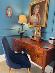a painting of a woman sitting on a chair in a room at Blaisdon House B&B in Longhope