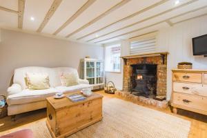 a living room with a couch and a fireplace at Oast Barn Cottage by Bloom Stays in Faversham