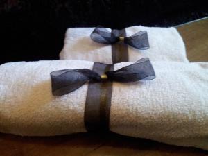 a white towel with blue bow ties on it at Casa De Fora in Aboim