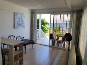 a living room with a table and a view of the ocean at Apartamentos Sound Bay Beach in San Andrés