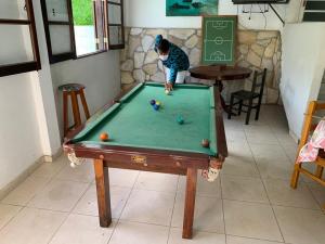 Una mujer jugando al billar en una mesa de billar en Pousada do Solar, en São Lourenço