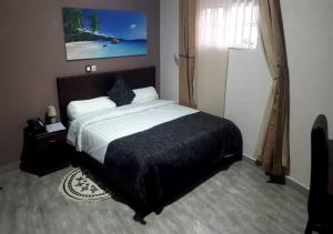 a bedroom with a large bed and a window at BENIN CITY CENTER HOTEL in Cotonou