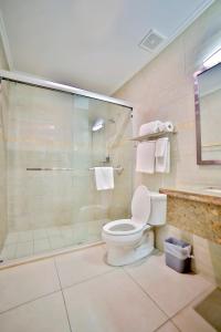 a bathroom with a toilet and a glass shower at Pearl Aruba Condos in Palm-Eagle Beach