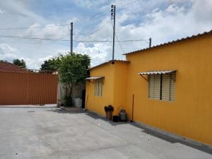 a yellow building with two windows and a fire hydrant at Pouso do Beija-Flor in Cavalcante