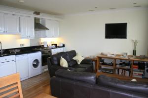 a living room with a couch and a kitchen at The Priory in Shanklin