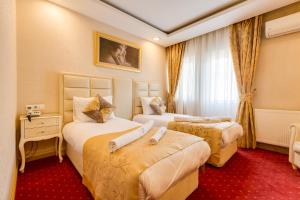 a hotel room with two beds and a window at Twins Hotel in Ankara