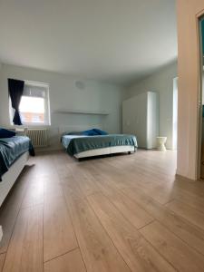 um quarto amplo com 2 camas e piso em madeira em Welcome Traveller LEA APARTMENTS em Garda