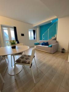 uma sala de estar com uma mesa e um sofá em Welcome Traveller LEA APARTMENTS em Garda