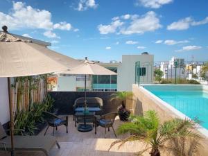 a patio with an umbrella and a swimming pool at Boca Inn Hotel & Suites in Veracruz