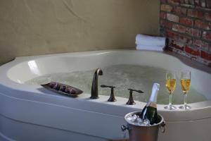 
a bathtub filled with a bucket of water and a bath tub with a at Paso Robles Inn in Paso Robles
