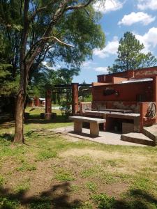 a park with two benches and a tree at Casona de campo in Santa María