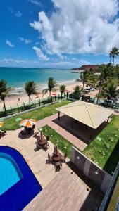 a view of the beach from a resort with a swimming pool at Tabatinga Residence Flat beira Mar in Conde