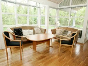 a living room with a couch and a table and chairs at 10 person holiday home in Hasle in Hasle