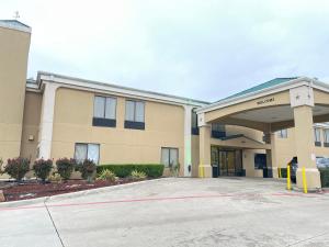 a building with a parking lot in front of it at Super 8 by Wyndham Fort Worth Downtown South in Fort Worth