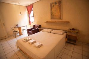 una camera da letto con un letto con due asciugamani sopra di Giardino Hotel a Itaquaquecetuba