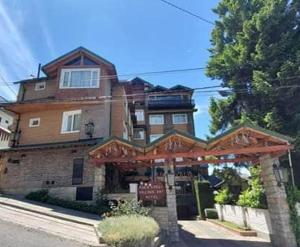 a large brick building with a sign in front of it at Ruca Cheli Village Ski Hotel in San Carlos de Bariloche