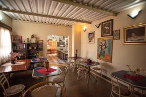 a room with tables and chairs and a kitchen at Giardino Hotel in Itaquaquecetuba