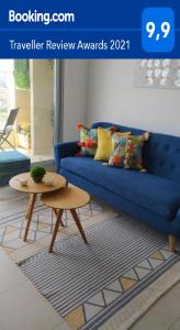 ein Wohnzimmer mit einem blauen Sofa und einem Tisch in der Unterkunft Espectacular Departamento Algarrobo Norte in Algarrobo