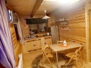 eine Holzküche mit Tisch und Kühlschrank in der Unterkunft Nexus B2 in Făgeţel