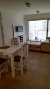 sala de estar con mesa y sofá en Deptos MORE II en Puerto Madryn
