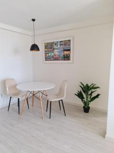 une salle à manger avec une table et des chaises blanches dans l'établissement AMUNATEGUI 213 Centro Iquique Ejecutivos, à Iquique