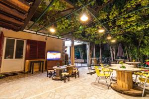 a patio with tables and chairs and a tv at Hostel Budva in Budva