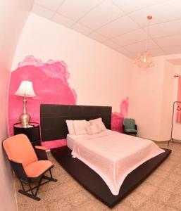 1 dormitorio con cama y pared de color rosa en Hostal Sole en Santa Ana
