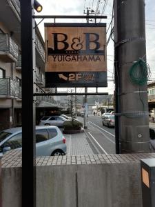 um sinal para um restaurante ao lado de uma rua em B&B YUIGAHAMA em Kamakura
