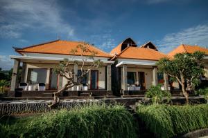 een huis met een oranje dak en enkele bomen bij Pandawa Resort & Spa Seaview in Nusa Penida