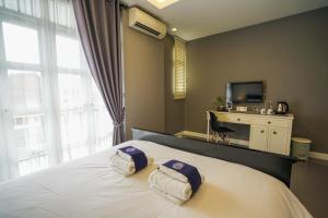 a bedroom with a bed with two towels on it at Casa VESPA at WUA LAI Boutique Hotel Chiang Mai in Chiang Mai