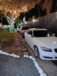 a white car parked next to a row of parked cars at The Beach Break Hotel in El Zonte