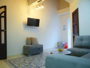 a living room with a couch and a chair and a tv at Cartagena Legends in Cartagena de Indias
