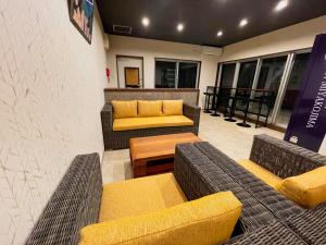 una zona soggiorno con divani e tavoli in un edificio di HOTEL Fit in Miyakojima a Miyakojima