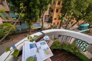 a balcony with a book and flowers and a street at Labevie Hotel in Hanoi