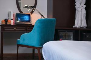 a blue chair in front of a desk with a computer at Labevie Hotel in Hanoi