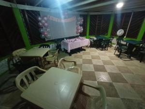 a room with a table and chairs and a projection screen at Ecocabañas Manguare in Puerto Nariño