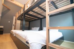 Un dormitorio con dos literas con sábanas blancas. en LA CHIC Stay Hakata Ⅱ, en Fukuoka