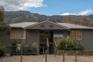a grey house with mountains in the background at Steamboat Unit 1 in Thredbo