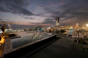 a rooftop pool with a view of a city at night at Green Suites Hotel in Ha Long