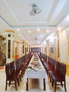 a long dining room with a long table with chairs at Anh Minh Hotel in Tam Ðảo