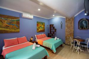 two beds in a room with blue walls at Hotel Arte Natura in Fortuna